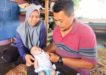 NUR Aisya Sumayyah Safidi berada di pangkuan bapa, Safidi Shaari sambil ditemani ibunya, Siti Aishah Md. Isa ketika ditemui di Kampung Bendang Padang, Kupang, Baling, Kedah.