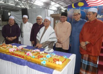 SAARANI Mohamad (tengah) memotong pulut kuning sempena meraikan ulang tahun hari kelahirannya yang ke-63 pada Majlis Berbuka Puasa Bersama Penjawat Awam Negeri Perak di Ipoh. - UTUSAN