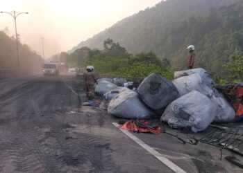 LALUAN dari Ipoh ke Terowong Menora di Lebuh Raya Utara-Selatan terhalang ekoran berlaku kemalangan disebabkan treler terbalik dengan muatan merintangi jalan dalam kejadian hari ini. - UTUSAN/IHSAN JBPM PERAK