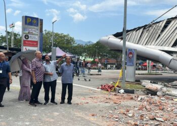 AMEER Ali Mydin (kiri) meninjau keadaan bangunan Pasar Raya Mydin Manjoi yang terbakar di Ipoh hari ini. - UTUSAN/LIYANA RAMLI