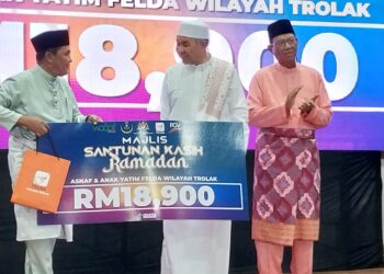 AHMAD Zahid Hamidi (tengah) menyampaikan sumbangan pada Program Iftar Majlis Santuni Kasih Ramadan di MRSM Felda di Tanjung Malim hari ini. - UTUSAN/AIN SAFRE BIDIN