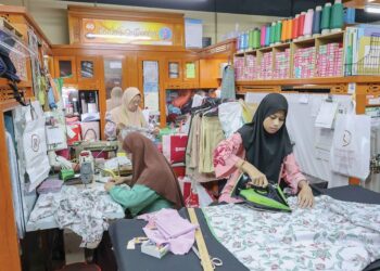 TUKANG jahit bertungkus-lumus menyiapkan tempahan baju raya menjelang sambutan Aidilfitri minggu depan di Pasar Rakyat, Medan Mara, Kuala Lumpur, semalam. - UTUSAN/AMIR KHALID