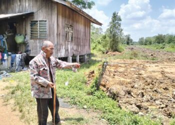 ZAKARIA Ismail menunjukan pekarangan rumahnya yang berhampiran dengan lokasi kebakaran hutan gambut di Kampung Tok Pelanduk, Batu Karang, Rantau Panjang, Kelantan, semalam. - UTUSAN/ROHANA ISMAIL