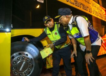 LOKMAN Jamaan (kanan) melihat anggota JPJ yang sedang memeriksa tayar bas ekspres ketika meninjau Op Khas Hari Raya Aidilfitri 2024 di Terminal Bas Shahab Perdana, Alor Setar. -UTUSAN/SHAHIR NOORDIN