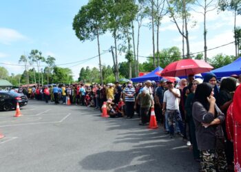 ORANG ramai beratur sepanjang kira-kira 200 meter seawal pukul 8 pagi bagi mendapatkan daging lembu tempatan yang dijual pada harga murah hasil inisiatif UMNO Kangar di Pusat Perniagaan Sena, Kangar, Perlis hari ini. -UTUSAN/IZLIZAN OTHMAN