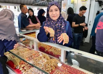 ROZLEEN Yusof menunjukkan rantai tangan yang menjadi pilihan wanita untuk Hari Raya Aidilfitri tahun ini di kedai emasnya di Pasar Siti Khadijah Kota Bharu. – UTUSAN/ ROSLIZA MOHAMED