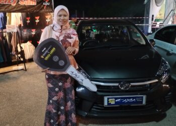 Norshaidatul Akma Borhan bersama Perodua Axia yang dimenangi menerusi cabutan bertuah Glam Bazar Ramadan Klebang, Melaka malam tadi. -UTUSAN/AMRAN MULUP