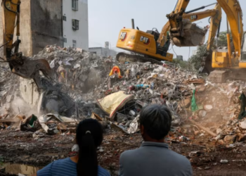 PENDUDUK  berdiri di hadapan bangunan yang sedang dirobohkan berikutan gempa bumi, di Hualien, Taiwan, semalam. -REUTERS