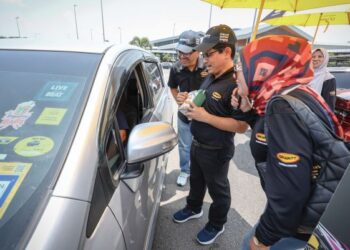 ANAS Nasrun Mohd. Osman (tengah) bersama Pengurus Besar UMW Grantt Lubricants, Iskandar Mohamed Salleh (kiri) menyantuni pengguna jalan raya sempena kempen keselamatan jalan raya di Hentian Rehat dan Rawat (RnR) Seremban, Lebuhraya Utara Selatan (Arah Selatan), semalam. – UTUSAN/MUHAMAD IQBAL ROSLI