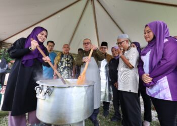 MOHD. ZOLKAFLY Harun (tengah) mengacau bubur lambuk pada Program Agihan Bubur Lambuk Ramadan di Kolej Antarabangsa Taj (TIC) di Ipoh hari ini. - UTUSAN