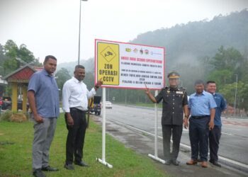 J. ARUL Kumar (dua dari kiri) dan Hazahar (tiga dari kanan) menunjukkan papan tanda amaran zon operasi CCTV di Jalan Seremban-Kuala Pilah dekat Ulu Bendol, Kuala Pilah hari ini.