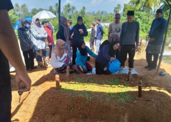 JENAZAH dua beradik yang maut dilanggar kenderaan pacuan empat roda di Jalan Ipoh-Kuala Kangsar dikebumikan di Tanah Wakaf Perkuburan Islam Kampung Perik, Enggor di Sungai Siput hari ini. - UTUSAN