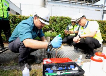 LING TIAN SOON (kanan) dan Dr. Mohd. Famey Yusoff melihat anggota JAS menguji sampel air pada Op Gempur Raya di Kawasan Perindustrian SILC, Iskandar Puteri.