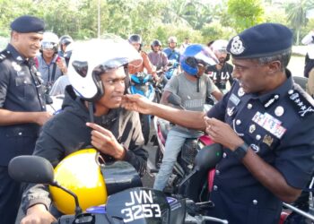 M. KUMAR (kanan) memakaikan topi keledar kepada seorang penunggang motosikal pada Program Advokasi Keselamatan Jalan Raya PDRM Johor Bersama Perkeso Johor sempena Op Selamat  Ke-22/2024 Hari Raya Aidilfitri di Plaza Tol Kempas ,Johor Bahru.