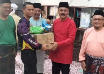 MD. ISRAKAbdullah (dua dari kanan) menyampaikan sumbangan kepada golongan asnaf di Masjid Pangkalan Raja, Pekan Nanas, Pontian.