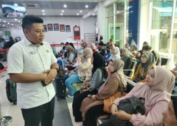 AZWAN Amin (kiri) berbual dengan  warga Indonesia yang pulang berhari raya  menggunakan TFAK di Kukup Laut, Pontian, Johor.