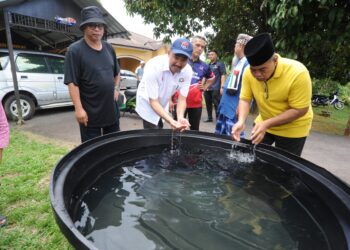 MOHD. JAFNI Md Syukor (dua dari kiri) melihat kualiti air bersih yang disalurkan ke dalam tangki ketika meninjau masalah bekalan gangguan air di Felda Bukit Permai, Kulai.