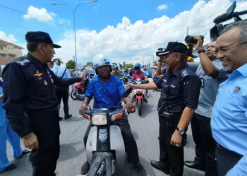 MUHAMAD Zaki Harun (kiri) menyampaikan sumbangan topi keledar kepada penunggang motosikal selepas merasmikan Program Keselamatan Jalan Raya Ops Selamat 22/2024 Sempena Hari Raya Aidilfitri 2024 di Binjal, Kota Bharu, Kelantan hari ini-UTUSAN/KAMARUL BISMI KAMARUZAMAN.