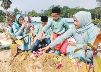 NORHISHAM Samsusah (kanan) bersama anak saudaranya, Eusuf Abdul Fatah menziarahi  pusara Bella di Tanah Perkuburan Islam Banang Jaya, Batu Pahat, Johor.