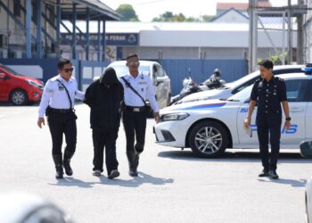 ANGGOTA polis mengiringi lelaki yang dipercayai terlibat kes langgar lari dua beradik untuk permohonan reman di IPD Ipoh hari ini. - UTUSAN