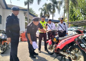 ABANG Zainal Abidin  Abang Ahmad memeriksa motosikal yang ditahan dalam Op Bersepadu Samseng Jalanan di Unit Penguatkuasaan Trafik IPD Ipoh di Jalan Chamberlain Hulu, Ipoh hari ini. - UTUSAN