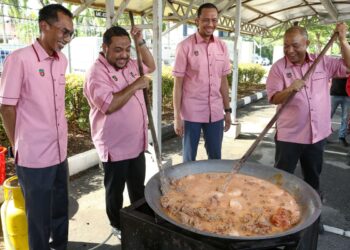 YAHANIS Yahya (dua dari kiri) menngacau rendang tok pada Program Jualan Rahmah Aidilfitri dan Rewang Ramadan Kakitangan Perak SADC di Ipoh hari ini. - UTUSAN/MUHAMAD NAZREEN SYAH MUSTHAFA