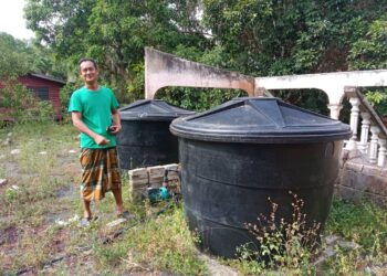 MOHD. SYUKRI Bakar menunjukkan dua buah tangki yang dibeli untuk menyimpan air di Kampung Bukit Nikmat Hulu di Jerantut, Pahang.