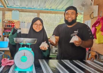 NURUL AZIDA Saidattul Akhmar (kiri) dan Norsalehudin Jamaludin menyiapkan santan yang ditempah pelanggan di kedai mereka di Tanjung Tualang di Batu Gajah.