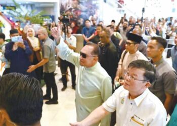 ANWAR Ibrahim menunjukkan isyarat bagus kepada orang ramai   ketika tiba di Komtar, George Town, Pulau Pinang, semalam.