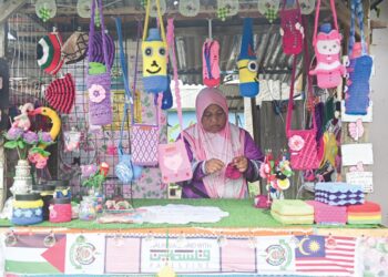 NUR Hafizah Hamzah mengait benang di gerai di hadapan rumahnya di Kampung Tanah Lot Baru Sekati, Manir, Kuala Terengganu, semalam. – UTUSAN/PUQTRA HAIRRY ROSLI