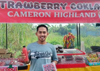 MUHAMMAD Al Bukhari Ellia menunjukkan produk jualan berasaskan buah strawberi di gerai jualannya di Bazar Ramadan Bagan Serai. - UTUSAN/WAT KAMAL ABAS