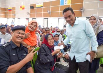 RUMINAH Sidek ceria menerima inisiatif Sumbangan Keceriaan kepada warga emas Negeri Sembilan sebanyak RM200 yang disampaikan Mohd. Isam di Jelai, Tampin  semalam.