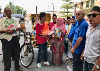 DR. Hafizah Mustakim (empat dari kanan) menyampaikan sumbangan raya kepada Mohd. Samsul Bahari Mat Yunan, di Dataran Kala, Kota Bharu, Kelantan hari ini.- UTUSAN/ ROSLIZA MOHAMED