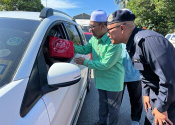 ABDUL Rahman Yunus (dua kanan) menyerahkan sumbangan kepada pengguna jalan raya selepas  merasmikan kempen keselamatan jalan raya di Bukit Yong, Pasir Puteh, Kelantan hari ini-UTUSAN/TOREK SULONG.