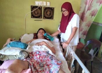 NOR AZIZAH Mohamad memberikan Mohd. Azizul Ismail minum susu  di rumahnya di Kampung Parit Terus, Sanglang, Pontian.