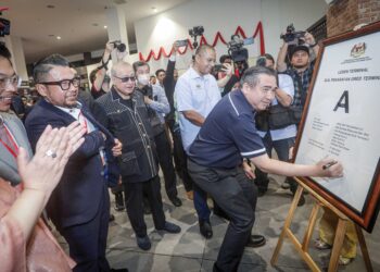 ANTHONY Loke menandatangani plak Sijil Penarafan Gred Terminal selepas merasmikan Pusat Pengangkutan Terminal KLIA2 dan Kempen ‘Relax, Reunite & Be Rewarded’ di Gateway@KLIA2 di Sepang, semalam. –UTUSAN/FAIZ ALIF ZUBIR