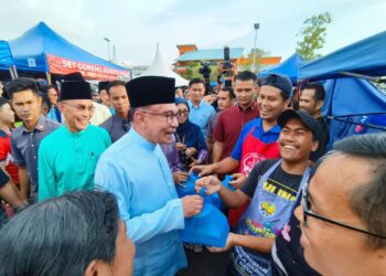 ANWAR Ibrahim beramah mesra dengan pengunjung di bazar Ramadan Persiaran Wawasan Kangar, Perlis hari ini.- UTUSAN/SYED AZLAN SAYID HIZAR