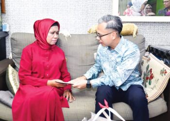 FAHMI Fadzil menyampaikan sumbangan kepada Zaiton Sameon melalui program Ziarah Seni Madani Finas, semalam. - FACEBOOK FAHMI FADZIL