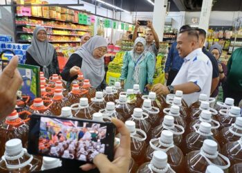 FUZIAH Salleh meninjau bekalan dan harga minyak masak ketika melakukan lawatan di Pasaraya LYC, dekat Kemunting, Kuantan, hari ini. UTUSAN/ DIANA SURYA ABD WAHAB