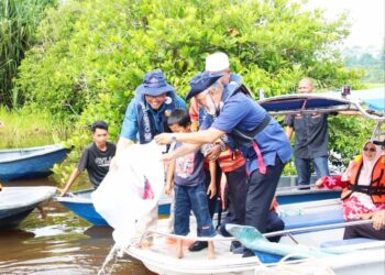 ADNAN Hussain melepaskan induk ikan Kelisa Emas pada program di Tasik Bukit Merah, Bagan Serai hari ini. - UTUSAN