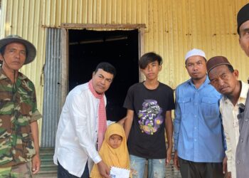 Mustapha Ahmad Marican (dua dari kiri) menyampaikan bantuan kepada anak yatim di Kampung Parahdau, sempadan Kemboja dan Vietnam hari ini.