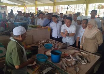 NGA Kor Ming menyantuni peniaga ketika melawat Pasar Awam Gerik hari ini. - UTUSAN