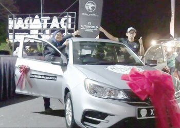 MUHAMMAD SHAHRODZY Abdul Halim (kanan) dan Wan Norhidayah Wan Mohd. (kiri) memenangi Proton Saga di bazar Aidilfitri Bukit Sekilau di Kuantan, Pahang. – UTUSAN/SHAIKH AHMAD RAZIF