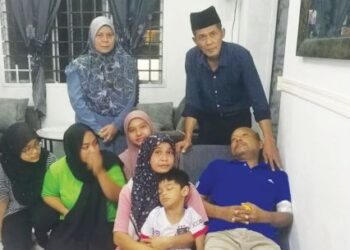 MUIHAMMAD Jalani yang terlantar bergambar bersama Muhamad Nizam (berdiri kanan) dan anggota keluarga di rumahnya di Apartmen Sri Ixora di Seksyen 27, Shah Alam, Selangor, baru-baru ini. – UTUSAN/ABDUL RAZAK IDRIS