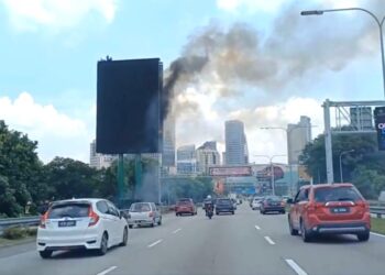 PARA pekerja penyelengaraan terperangkap di bahagian atas papan iklan elektrik yang terbakar di Lebuh Raya Persekutuan, Petaling Jaya, hari ini.