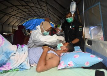 SEORANG jururawat merawat mangsa gempa bumi di wad sementara Hospital Besar Sulawesi Barat.-AFP