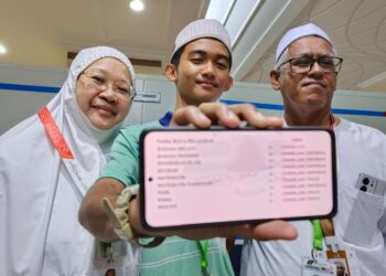 MUHAMMAD Ameer Che Noor Azam ditemani ibu bapa menunjukkan keputusan cemerlang SPM 2023 di Mekah semalam.