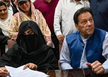 BUSHRA Bibi (kiri) dan Imran Khan menandatangani bon penjamin di pejabat pendaftar Mahkamah Tinggi di Lahore.-AFP