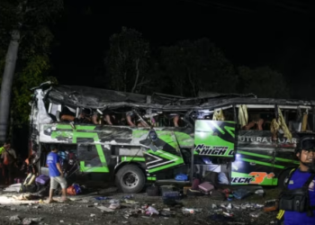 PIHAK berkuasa memeriksa serpihan dan barang-barang penumpang selepas kemalangan bas di Indonesia, semalam. -AFP