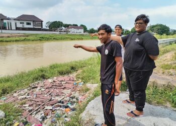 MUHAMMAD NURIMAN Ahmad bersama dua rakannya menunjukkan lokasi kejadian buaya membaham kambing di Sungai Malim, Kampung Tengah, Melaka. - UTUSAN/AMRAN MULUP